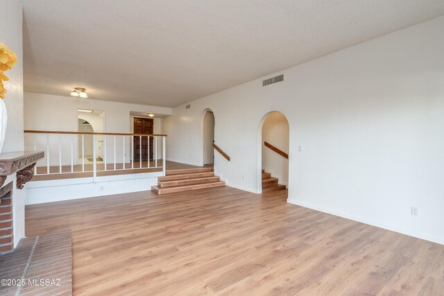 538 N Dodge Blvd, Tucson, AZ 85716 - unfurnished room featuring stairs, visible vents, light wood-style floors, and arched walkways