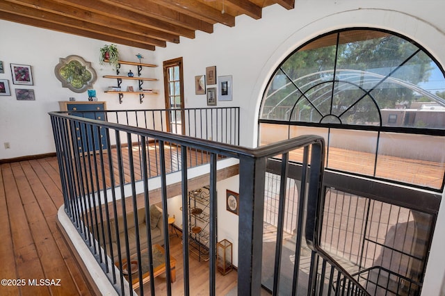 stairway with hardwood / wood-style floors, baseboards, and beamed ceiling