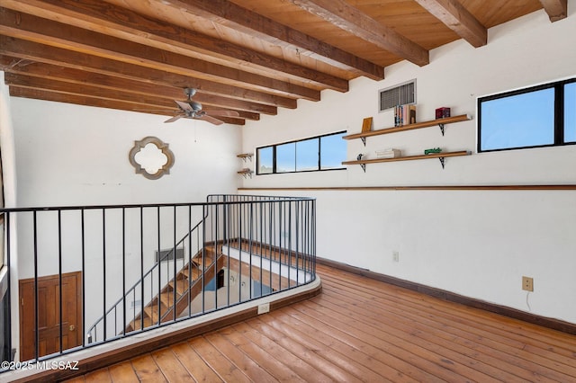 interior space featuring beam ceiling, wood ceiling, a ceiling fan, visible vents, and hardwood / wood-style floors