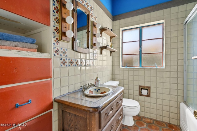 full bath with tile walls, toilet, tile patterned flooring, and vanity