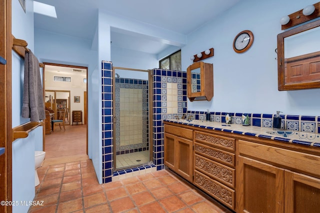 bathroom with double vanity, toilet, tile patterned flooring, and a shower stall