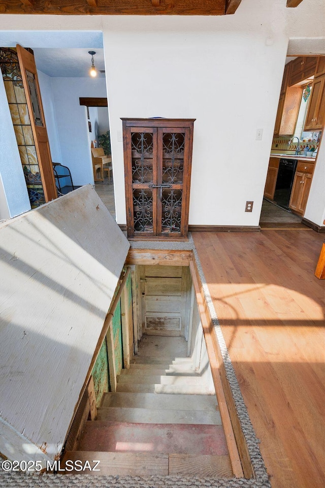 stairway with baseboards and wood finished floors