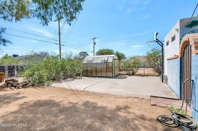 view of patio with an outbuilding, an exterior structure, and fence