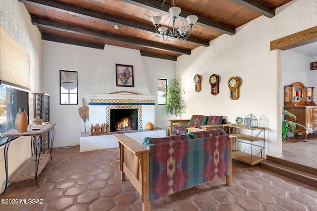 living area with beamed ceiling, a fireplace, an inviting chandelier, and wooden ceiling