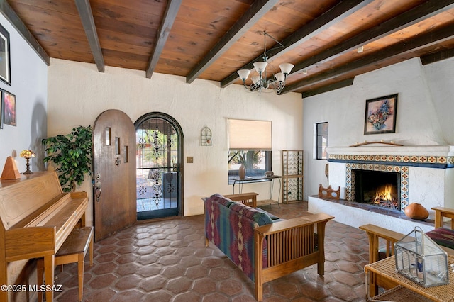 living room with an inviting chandelier, wooden ceiling, beam ceiling, and a premium fireplace