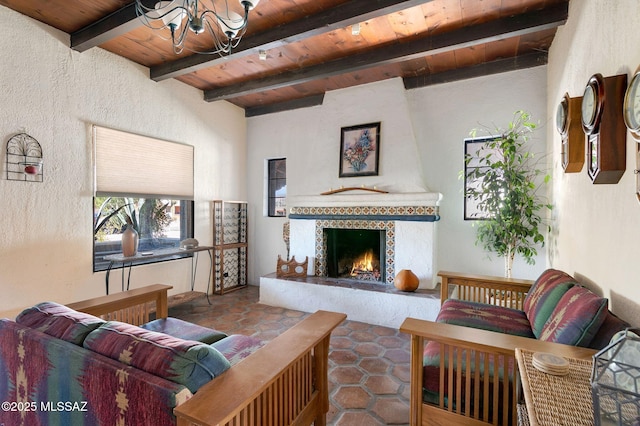 living area with a large fireplace, a chandelier, wooden ceiling, and beam ceiling