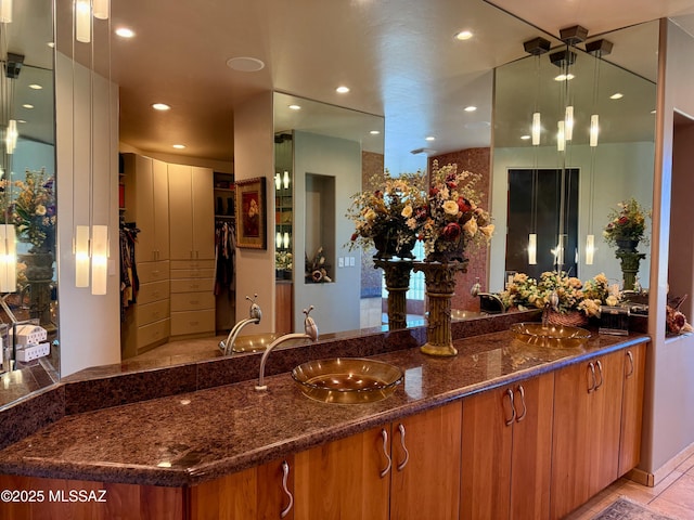 interior space with recessed lighting, light tile patterned floors, indoor wet bar, a sink, and pendant lighting