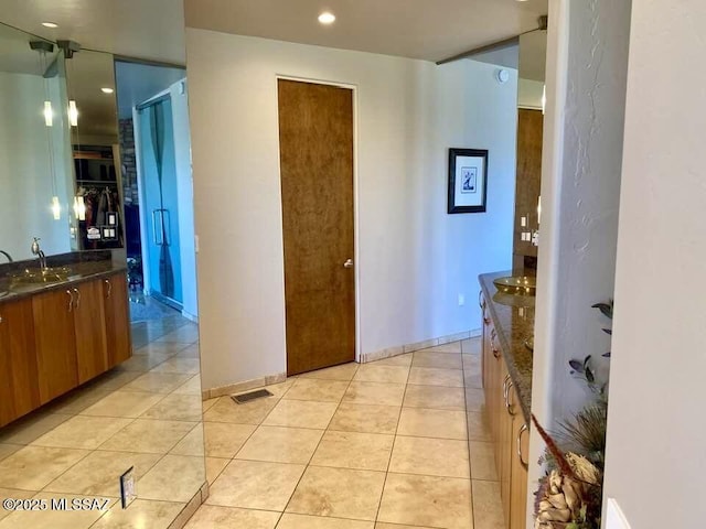 hall with a sink, recessed lighting, visible vents, and light tile patterned floors