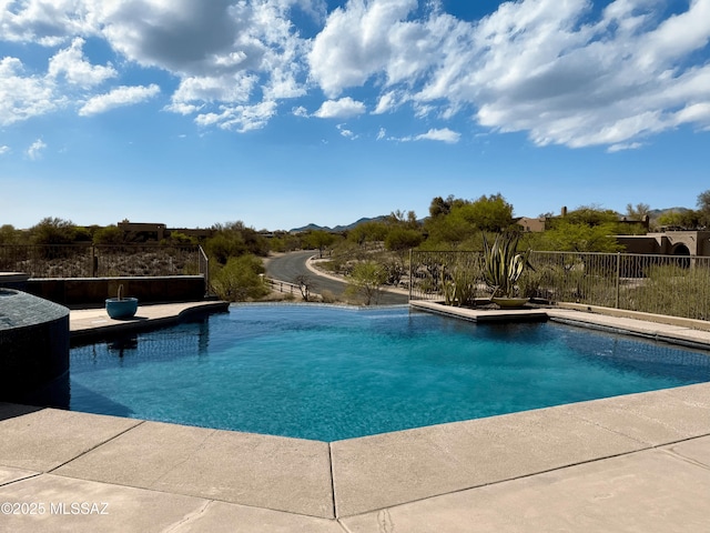 view of swimming pool featuring fence, a mountain view, and a fenced in pool