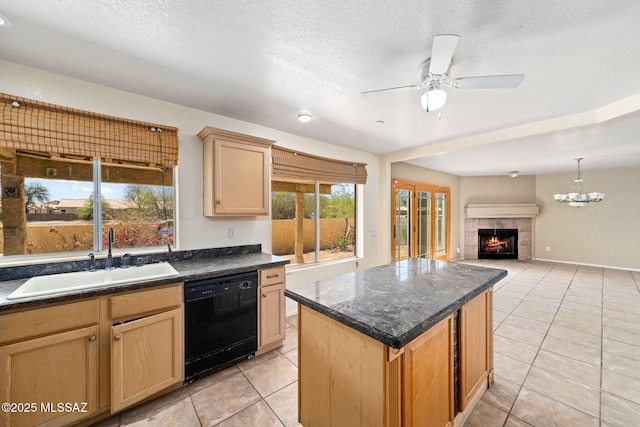 kitchen with black dishwasher, ceiling fan with notable chandelier, dark countertops, and a sink