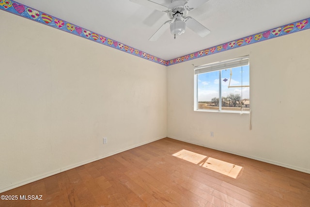 empty room with hardwood / wood-style floors, ceiling fan, and baseboards