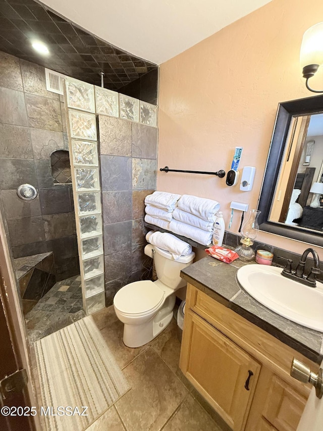full bath featuring tile patterned floors, toilet, a walk in shower, and vanity