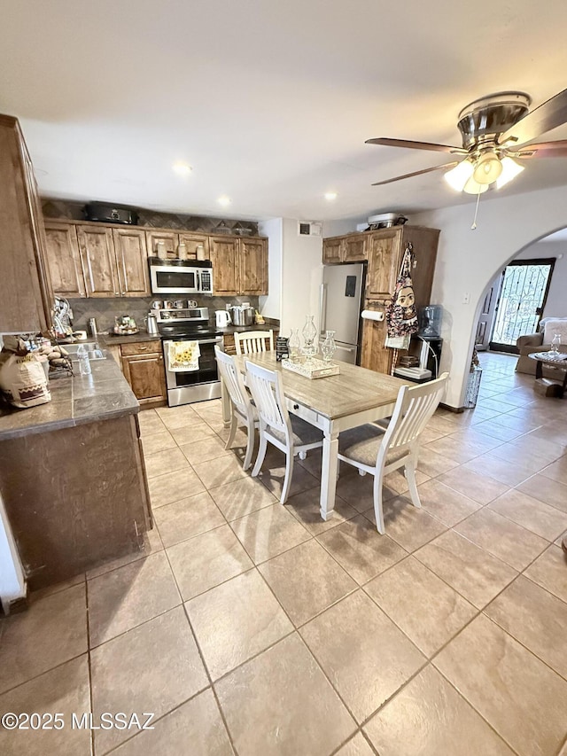 dining area featuring recessed lighting, light tile patterned flooring, arched walkways, visible vents, and a ceiling fan