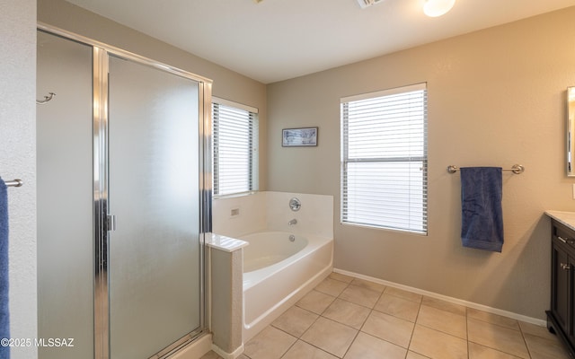 bathroom with tile patterned flooring, vanity, baseboards, a stall shower, and a garden tub
