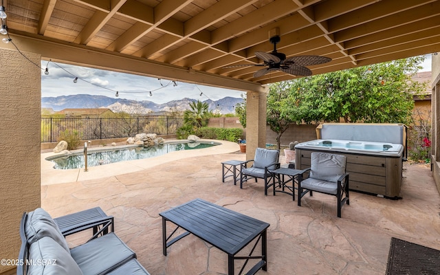 view of patio / terrace with a fenced in pool, a ceiling fan, a hot tub, a fenced backyard, and a mountain view