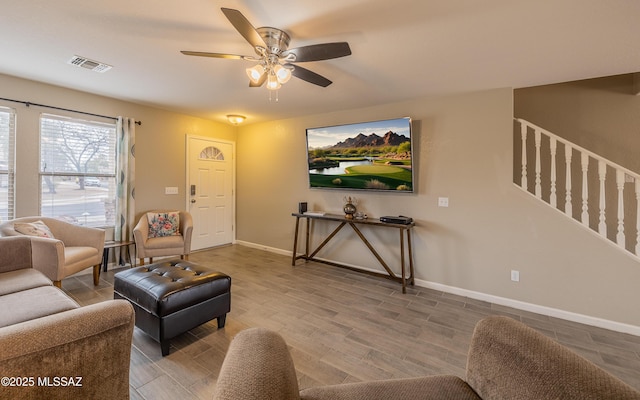 living room featuring baseboards, visible vents, wood finished floors, and ceiling fan