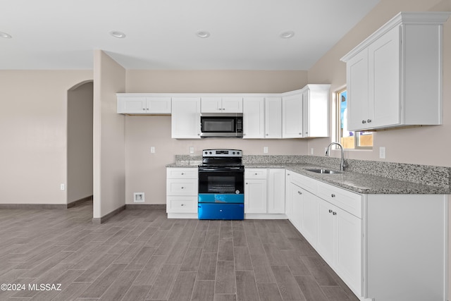 kitchen with white cabinetry, stainless steel microwave, electric range, a sink, and light stone countertops