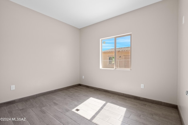 unfurnished room featuring baseboards and wood finished floors