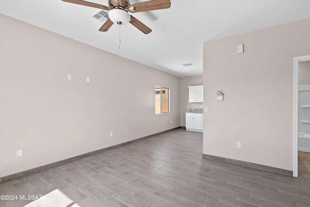 unfurnished living room with baseboards, ceiling fan, visible vents, and light wood-type flooring