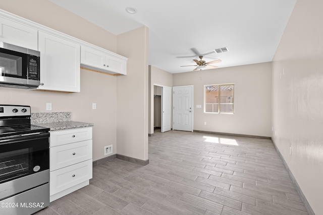 kitchen featuring light stone counters, light wood finished floors, stainless steel appliances, white cabinets, and ceiling fan