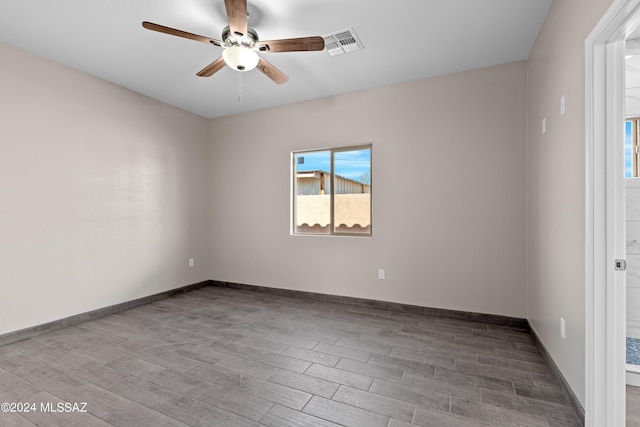 unfurnished room featuring baseboards, ceiling fan, visible vents, and wood finished floors
