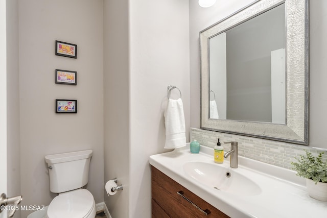 bathroom with vanity, decorative backsplash, and toilet