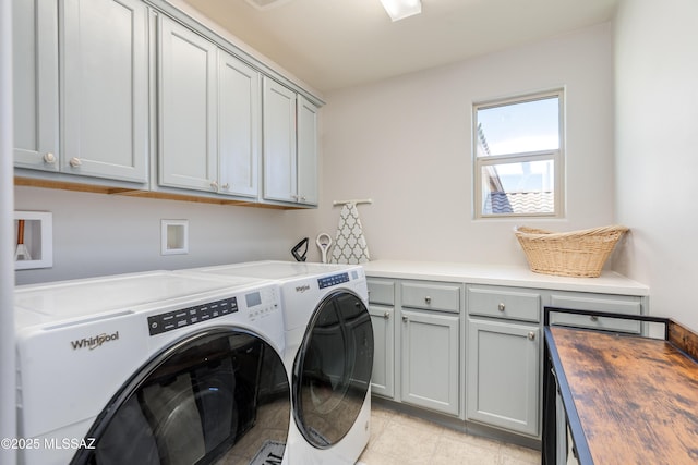 laundry room featuring cabinet space, washing machine and dryer, and light tile patterned floors