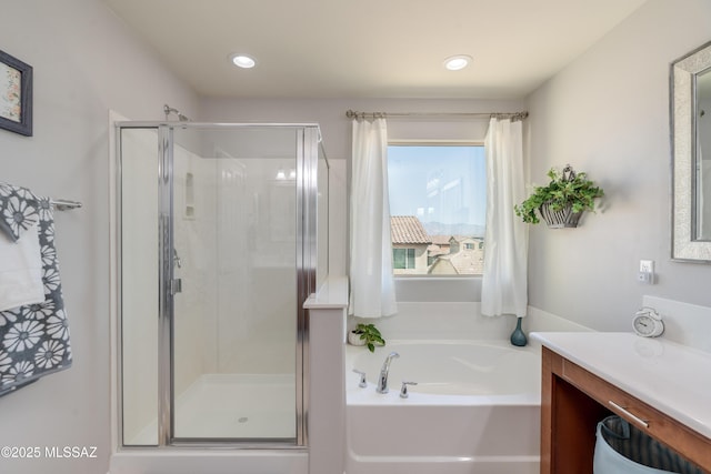 bathroom featuring vanity, a shower stall, recessed lighting, and a garden tub
