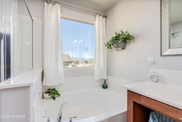 bathroom with vanity and a bath