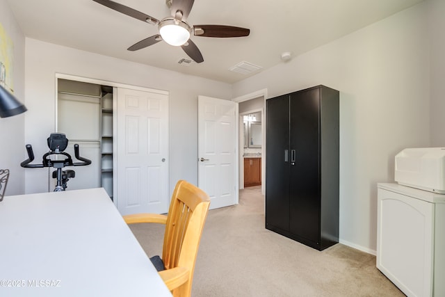 office space with a ceiling fan, baseboards, visible vents, and light carpet
