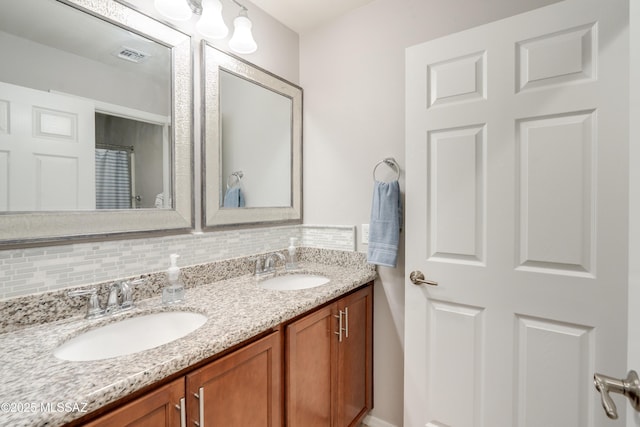 full bath featuring double vanity, a sink, decorative backsplash, and visible vents