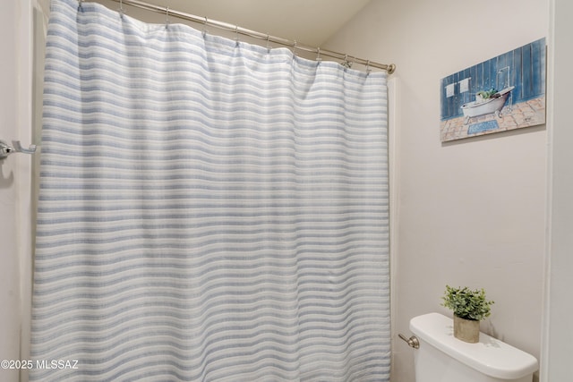 bathroom featuring curtained shower and toilet