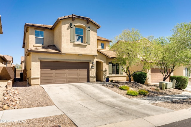 view of front facade featuring a garage, stucco siding, a tiled roof, and concrete driveway