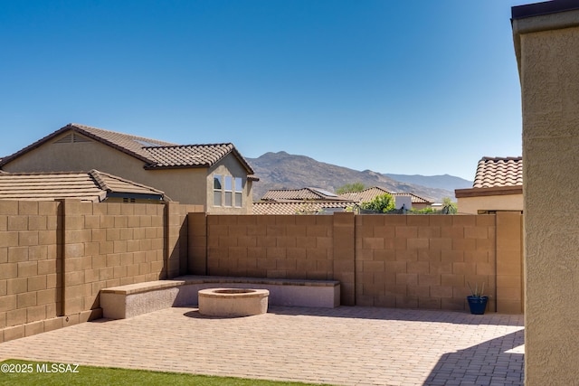 view of patio / terrace with fence and a mountain view