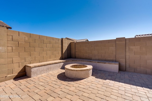 view of patio featuring fence and a fire pit