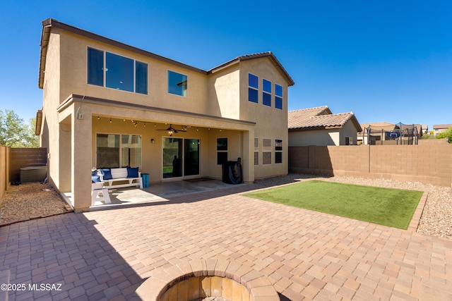 rear view of property with a patio, a fenced backyard, ceiling fan, and stucco siding