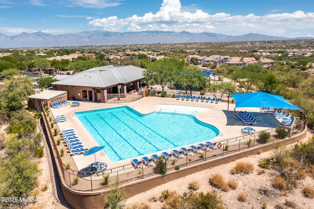 pool featuring fence, a patio, and a mountain view
