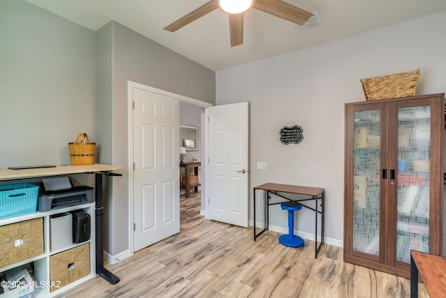 interior space featuring light wood-type flooring, baseboards, ceiling fan, and visible vents