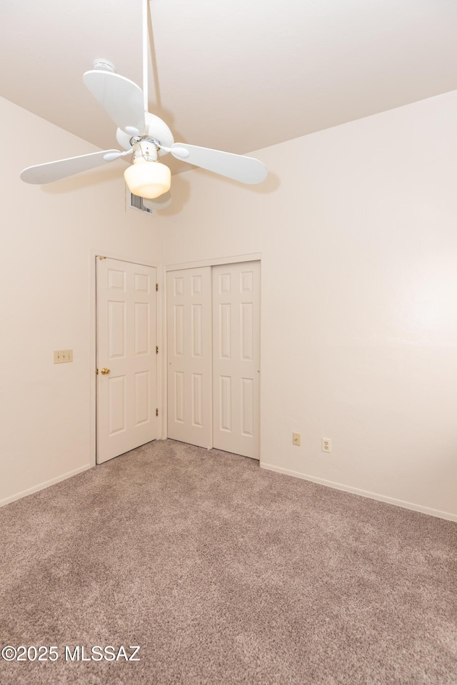 carpeted spare room with a ceiling fan, baseboards, and visible vents