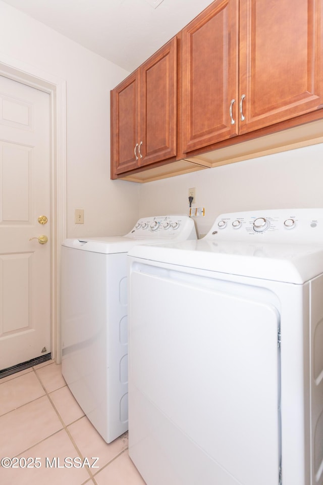 washroom featuring light tile patterned floors, cabinet space, and washer and dryer