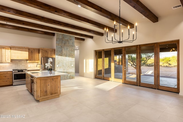 kitchen with visible vents, a high ceiling, light countertops, a sink, and stainless steel appliances