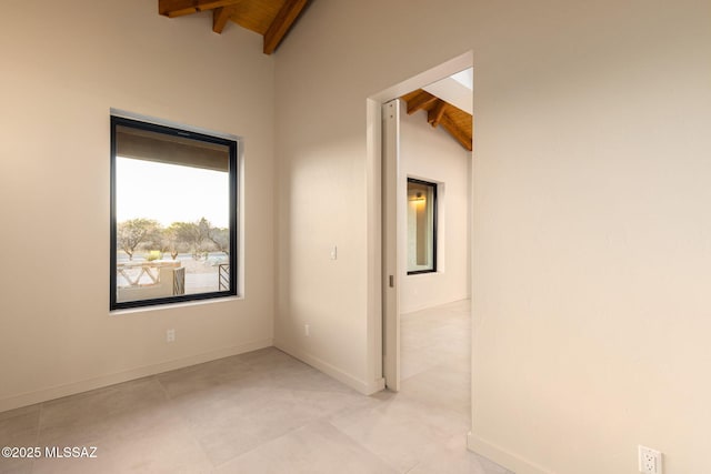 spare room with wooden ceiling, baseboards, and lofted ceiling with beams