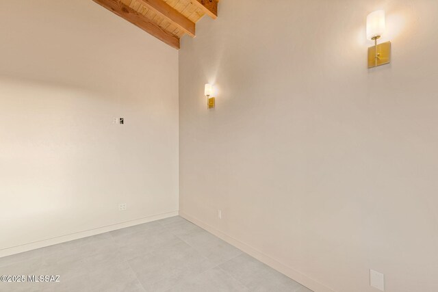 empty room featuring baseboards, wooden ceiling, and beam ceiling