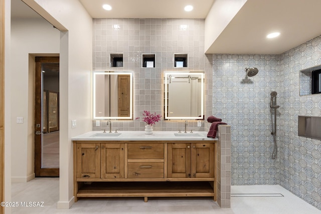 bathroom featuring double vanity, walk in shower, and a sink