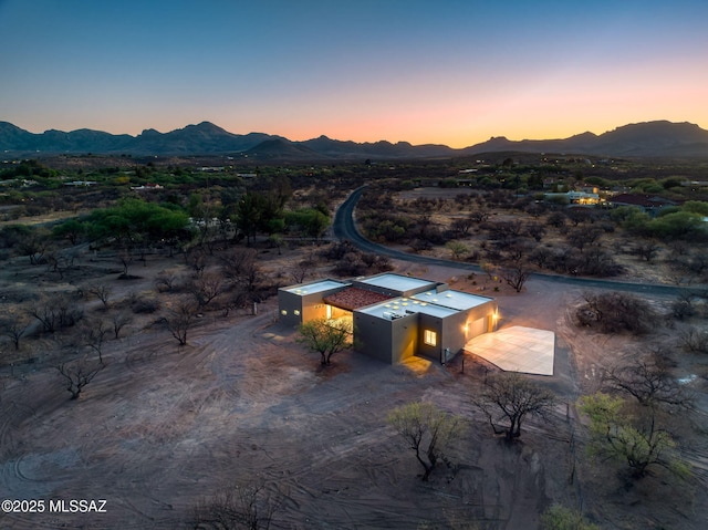 aerial view at dusk with a mountain view, view of desert, and a rural view