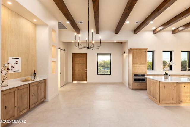 kitchen with oven, a healthy amount of sunlight, a barn door, and visible vents