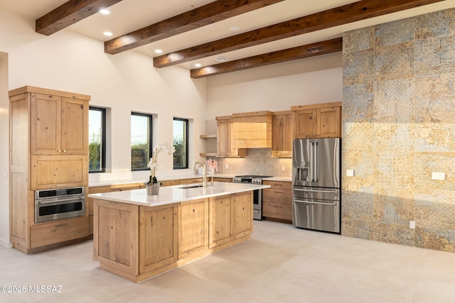 kitchen with decorative backsplash, a towering ceiling, appliances with stainless steel finishes, light countertops, and a sink