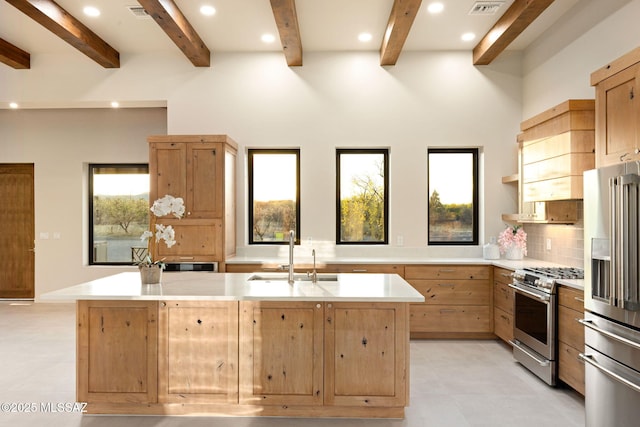kitchen featuring a sink, beamed ceiling, appliances with stainless steel finishes, and light countertops