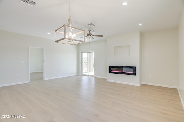 unfurnished living room featuring a glass covered fireplace, light wood finished floors, recessed lighting, and visible vents