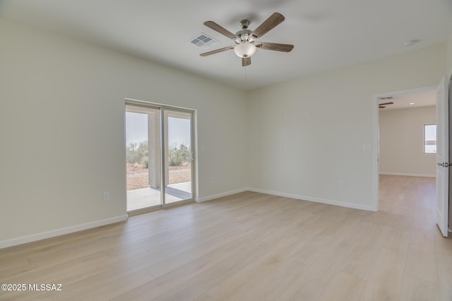 unfurnished room with baseboards, a ceiling fan, light wood-type flooring, and visible vents